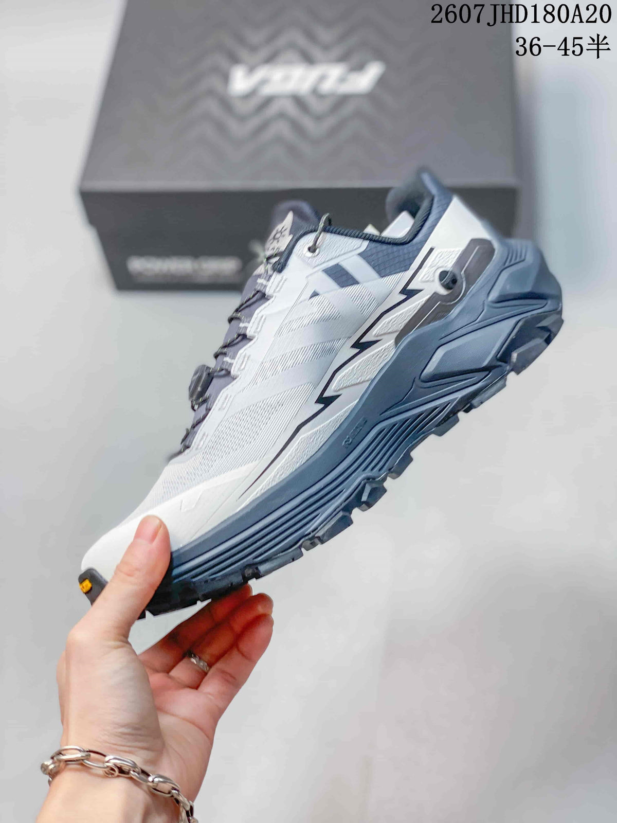 Side profile showing the white and gray upper, navy midsole and rugged low-top hiking construction.