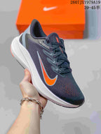 Angled side view of the Nike Zoom Winflo 7 running shoe showing the dark gray upper, orange swoosh, white midsole, and black outsole; image text shows style code 2607JXY979A19 and size range 39–45.