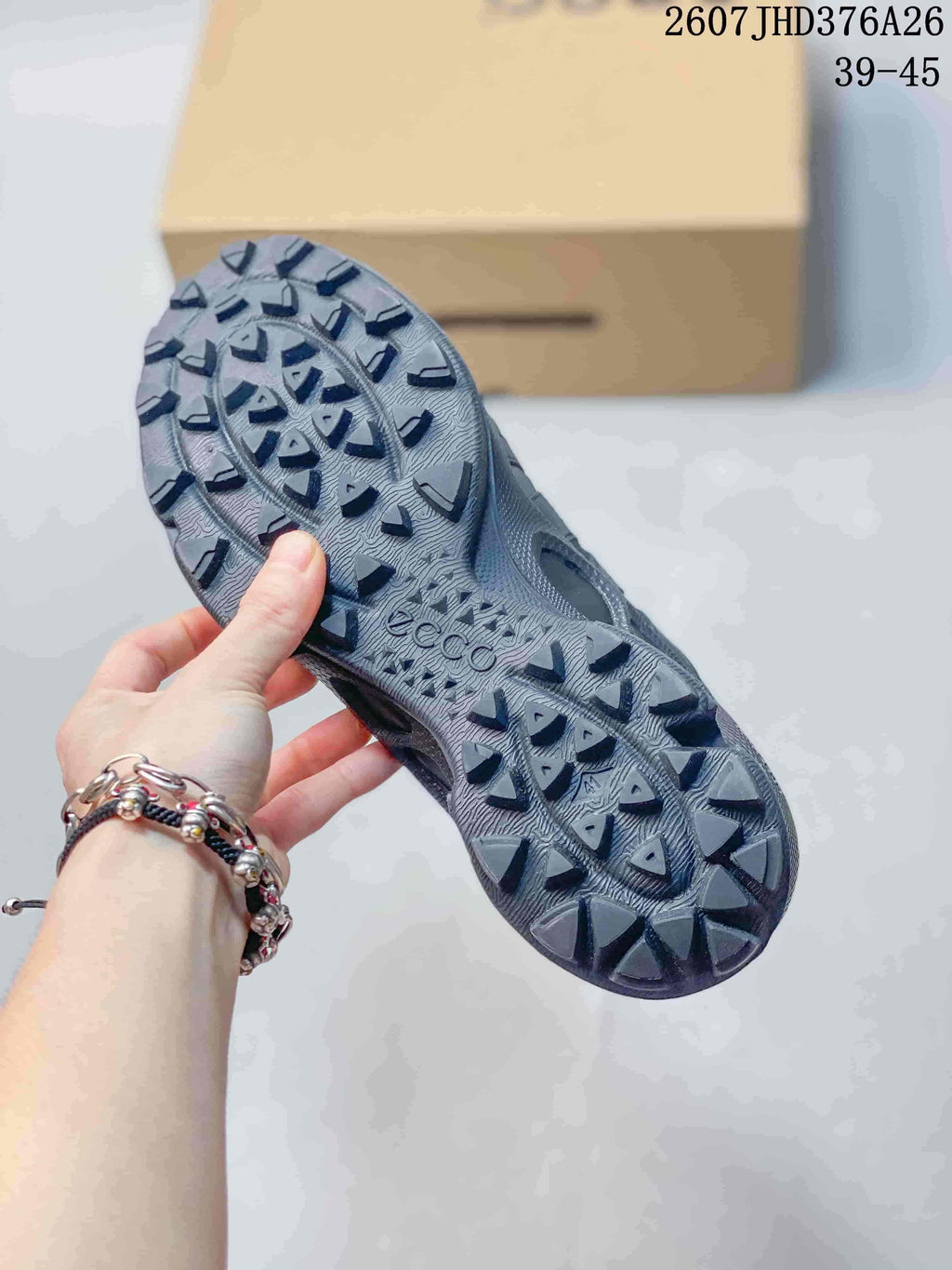 Underside of a black sneaker showing the patterned outsole and raised traction lugs.