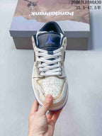 Front view of the sneaker showing its navy tongue, white laces, and perforated toe.