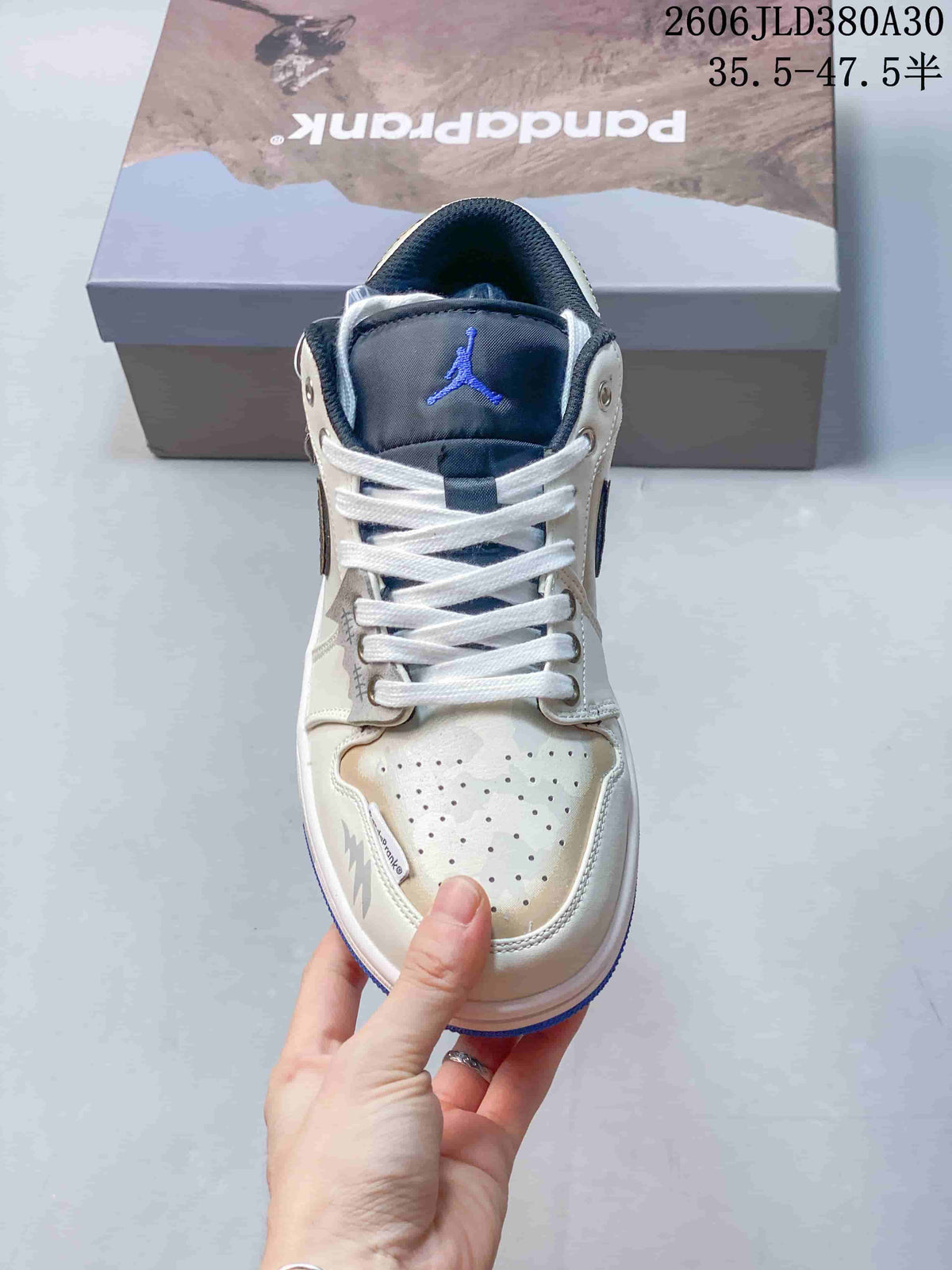 Front view of the sneaker showing its navy tongue, white laces, and perforated toe.