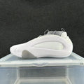 Side view of a gray and white low-top sneaker with a sculpted side panel and lace-up closure.