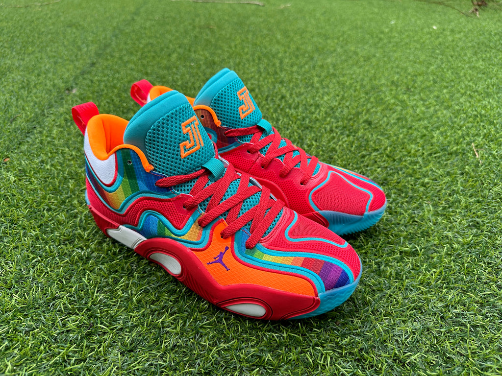 Pair of multicolor Jordan high-top basketball shoes on grass