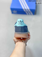 Rear view showing the navy heel, turquoise heel tab, adidas Trefoil branding, and gum-colored outsole.