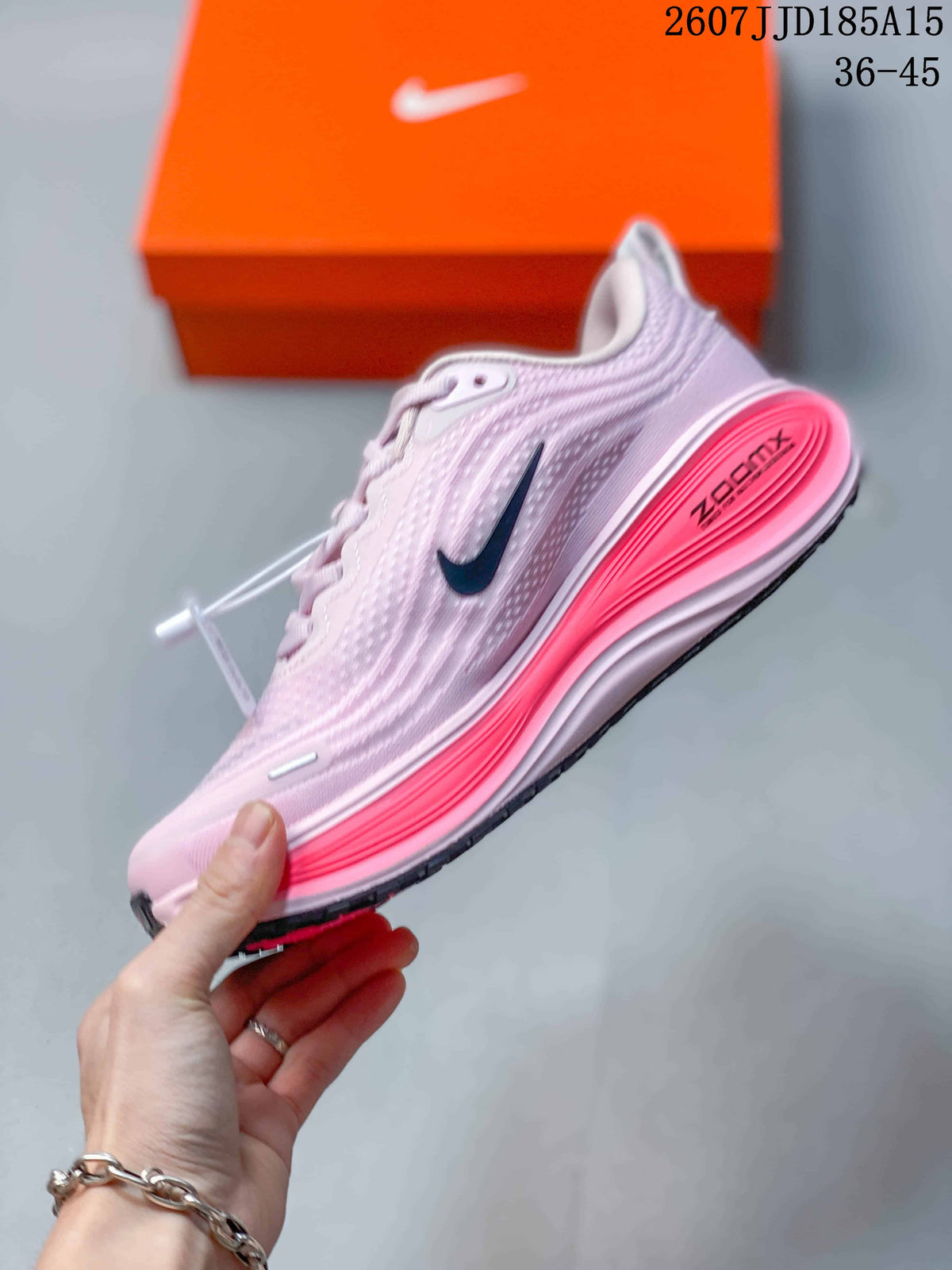 Side view of a pale pink Nike running shoe showing the dark Swoosh, textured upper, layered pink midsole, and outsole.