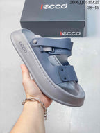 Side view of a blue-gray adjustable strap sandal with a molded footbed and raised sole edge.