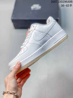 Side view of the white sneaker showing the Swoosh, layered panels, perforations, and textured outsole.