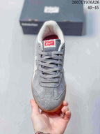 Top view of the gray lace-up sneaker showing the rounded toe, gray laces, padded collar, and Onitsuka Tiger tongue label; image text shows style code 2607LY976A26 and size range 40–45.