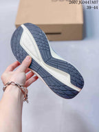 Close view of the sneaker outsole showing a dark patterned rubber tread and a light-colored midsole section.