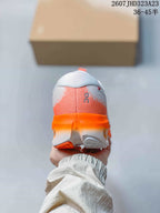 Rear view of the white and orange sneaker showing the padded heel and layered outsole.