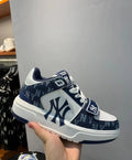 Navy and white MLB 003-1 sneaker with repeated monogram-style lettering, New York emblems, white laces, and a wide strap.