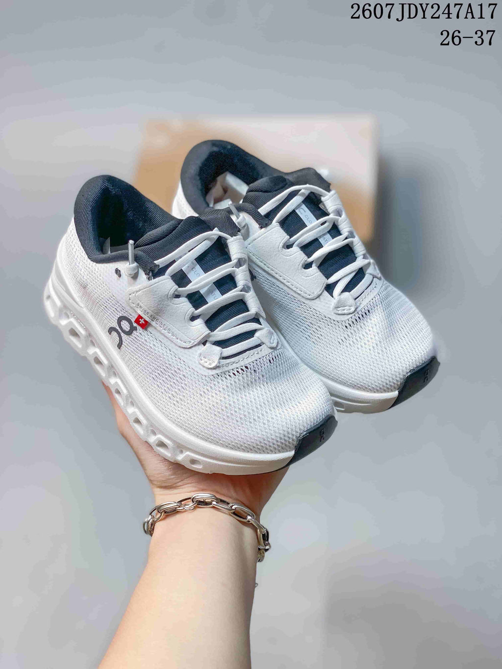 Pair of white On low-top running sneakers shown from above, with dark collars and segmented soles.