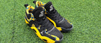 Pair of black and yellow leopard-print high-top sneakers on grass