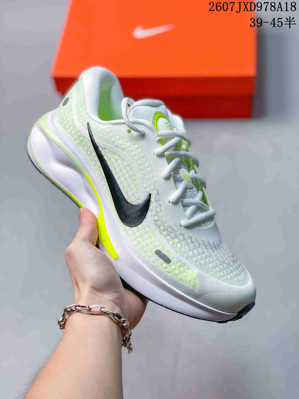 Light-colored Nike Journey Run sneaker with black logo, neon yellow-green accents, and a sculpted heel sole.