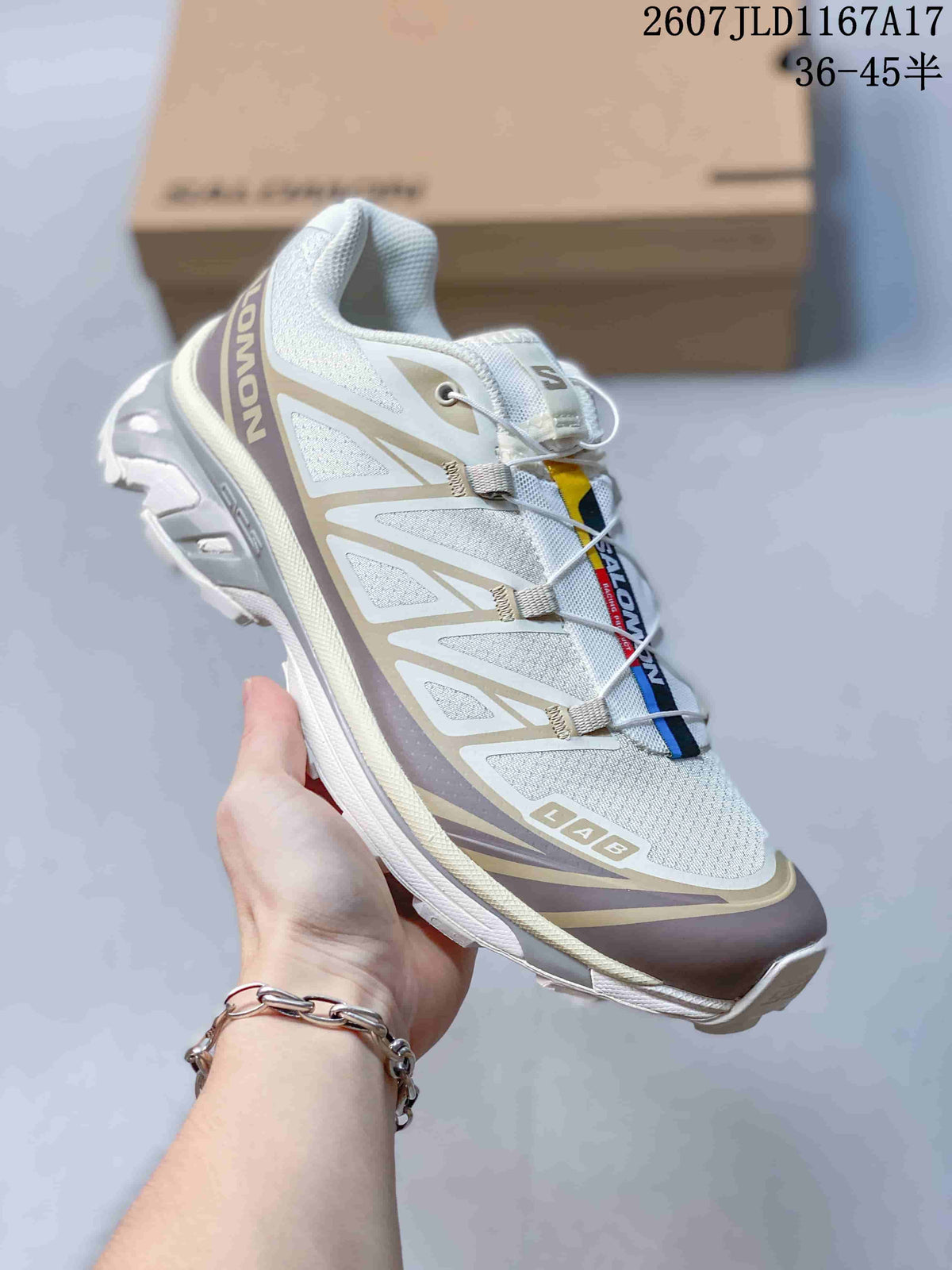Angled side view of one Salomon XT-6 sneaker showing the quick-lace system, layered side panels, heel branding, and lugged outsole.