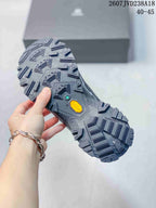 Close view of the hiking shoe outsole showing a large geometric lug pattern and branded outsole inserts.