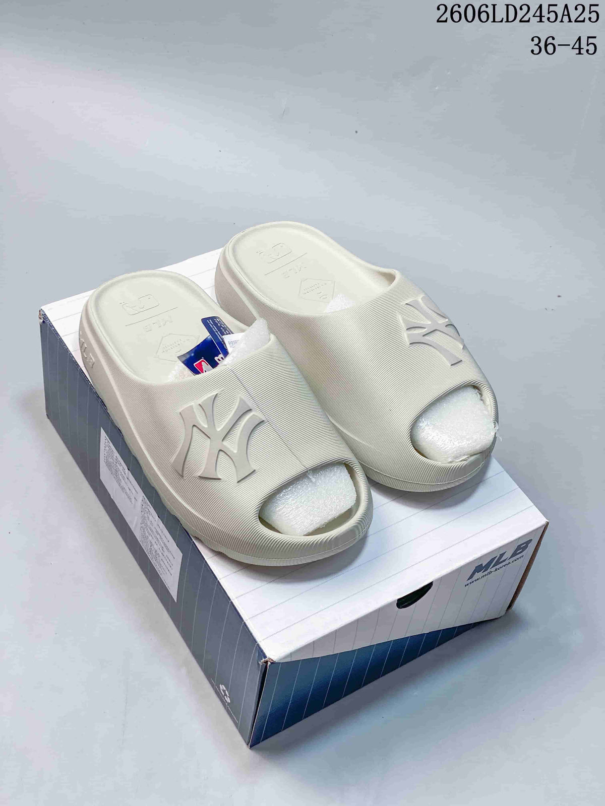 Pair of off-white MLB logo slide sandals displayed on a branded shoe box.