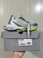 Side profile of the sneaker resting on its box; the box label visibly shows model 9074 and a C 37 size marking.