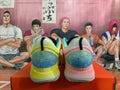 Rear view of the mismatched yellow and pink Nike basketball sneakers, showing teal heel panels.
