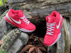 Pair of pink Nike Kobe 4 shoes with white laces and side Swoosh details.