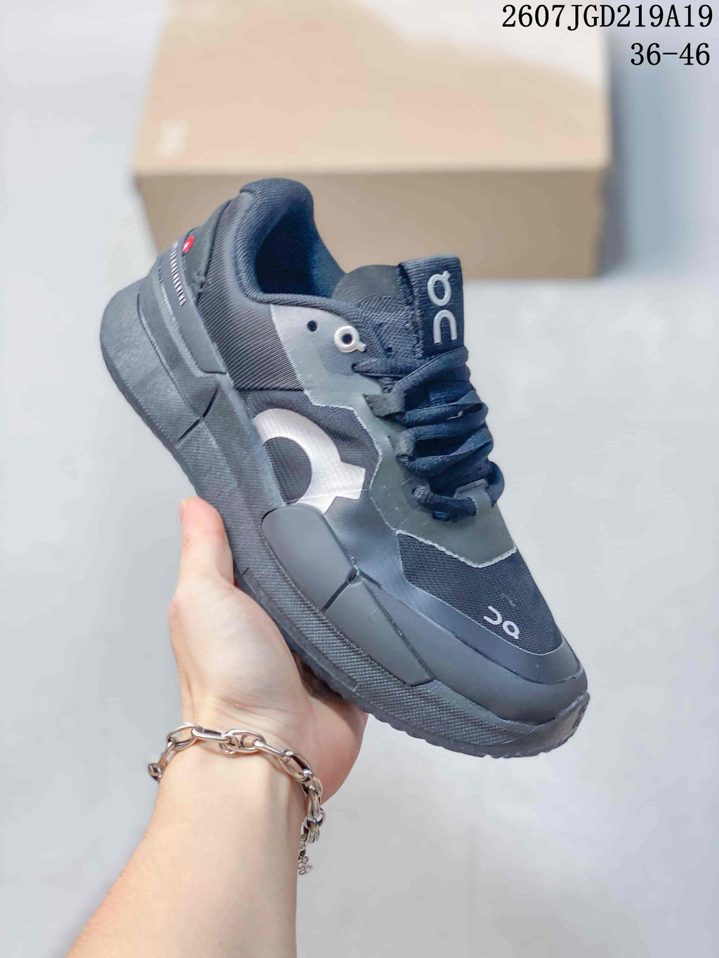 Angled side view of the black On tennis shoe showing the layered upper, padded collar and sole structure.
