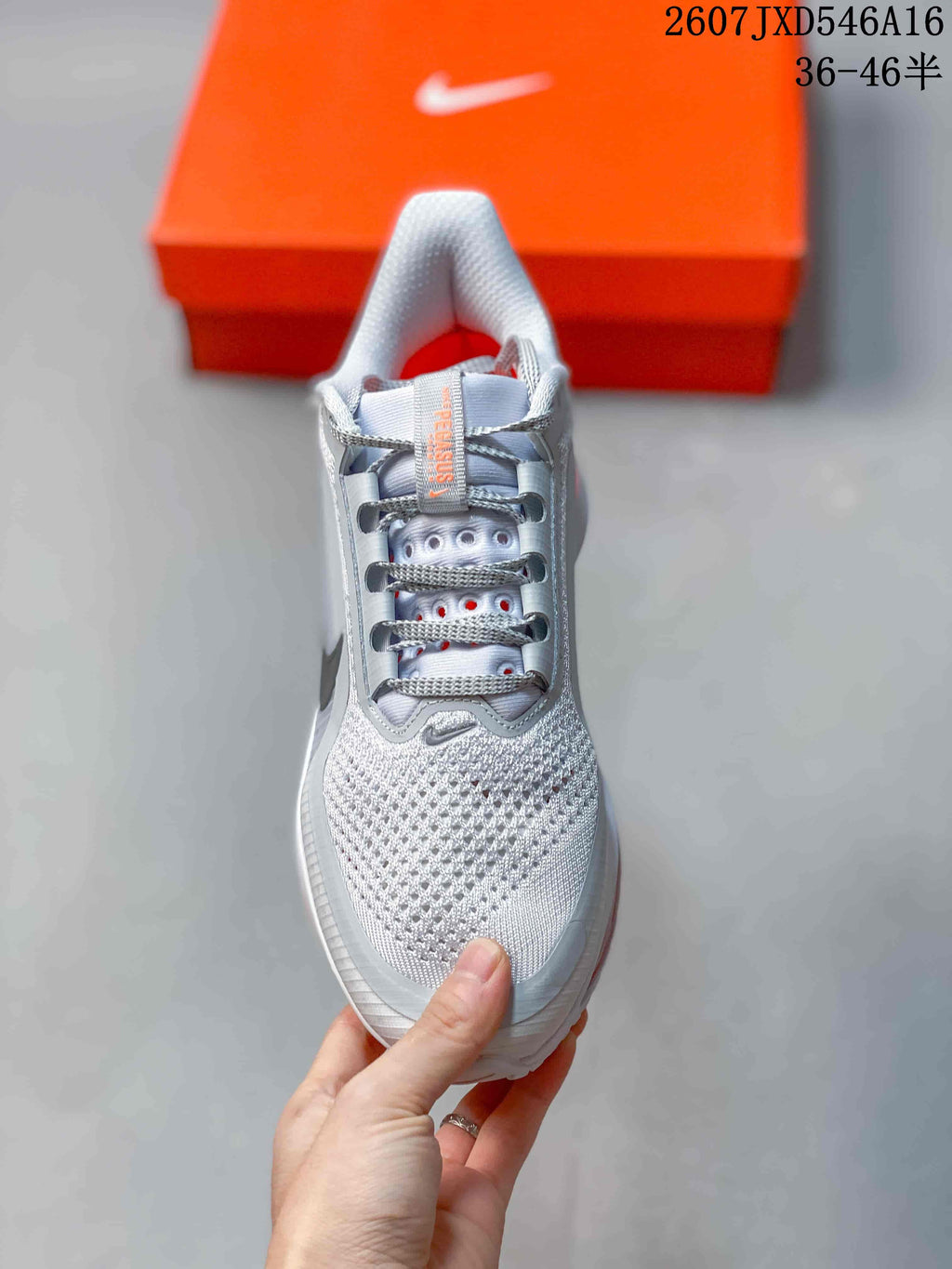 Top view of the sneaker showing the perforated forefoot, gray laces, padded collar, and orange interior details.