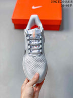 Top view of the sneaker showing the perforated forefoot, gray laces, padded collar, and orange interior details.