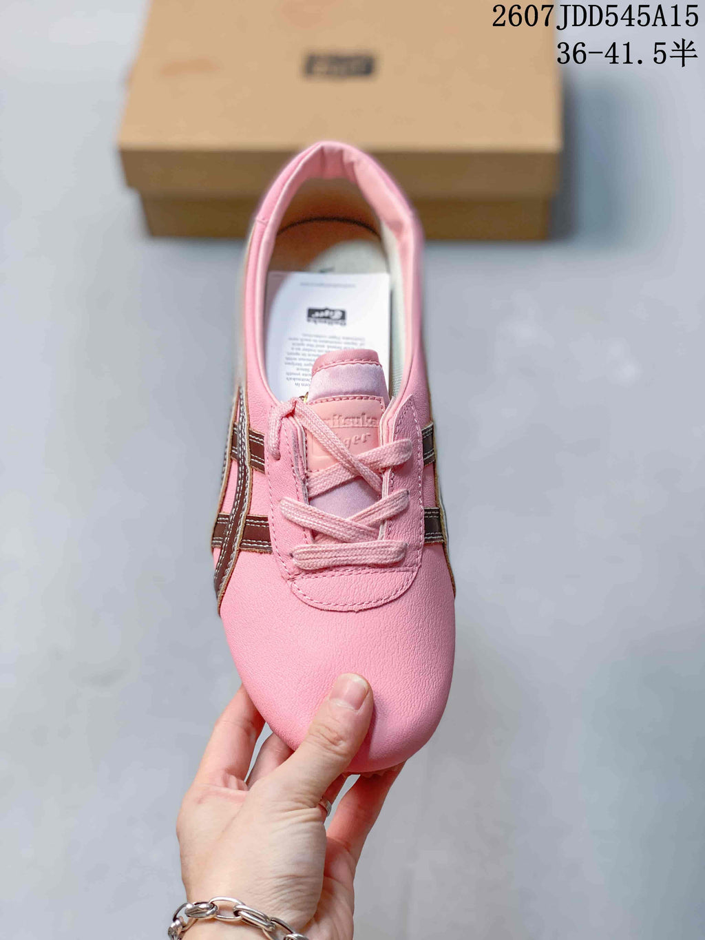 Top view of the pink lace-up sneaker showing the rounded toe, tongue, and side stripes.