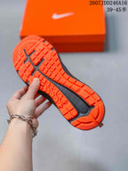 Close view of the orange outsole showing its textured traction pattern and black central sections.