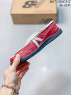 Side profile highlighting the red upper, white detailing, lace-up construction, and low-profile sole.
