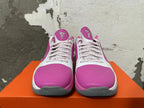 Front view of pink and white Nike basketball shoes with patterned laces and gray toe accents.