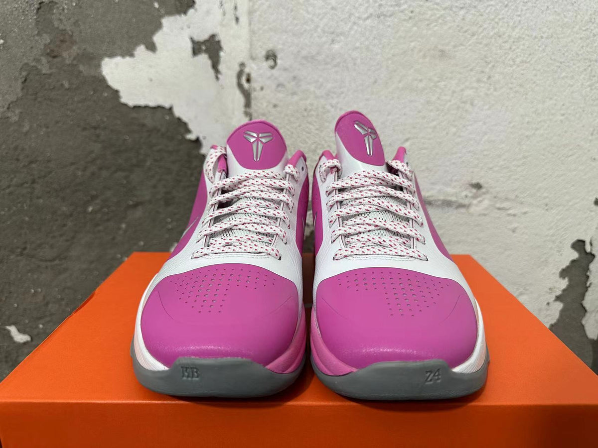 Front view of pink and white Nike basketball shoes with patterned laces and gray toe accents.