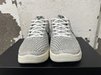 Front view of white and grey Nike basketball shoes with white laces and textured patterned uppers.