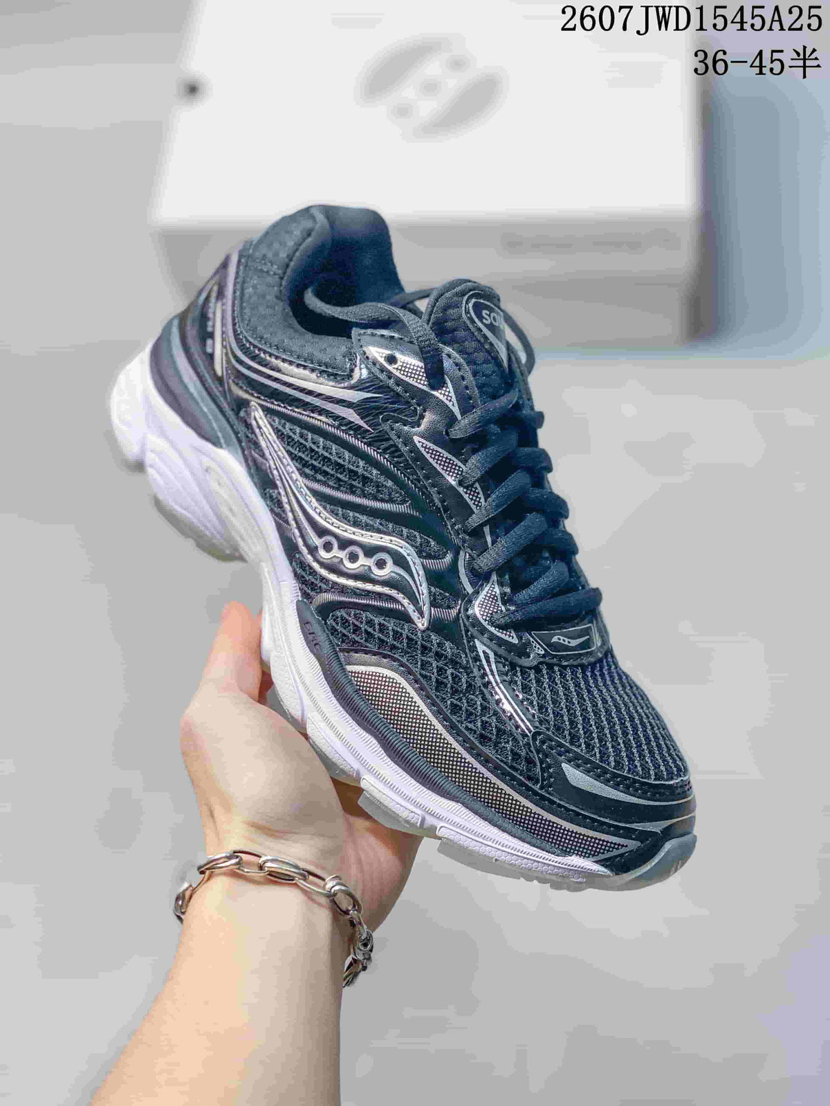 Angled side view of the Saucony ProGrid Omni 9 sneaker showing the dark upper, reflective-looking overlays and white sole.