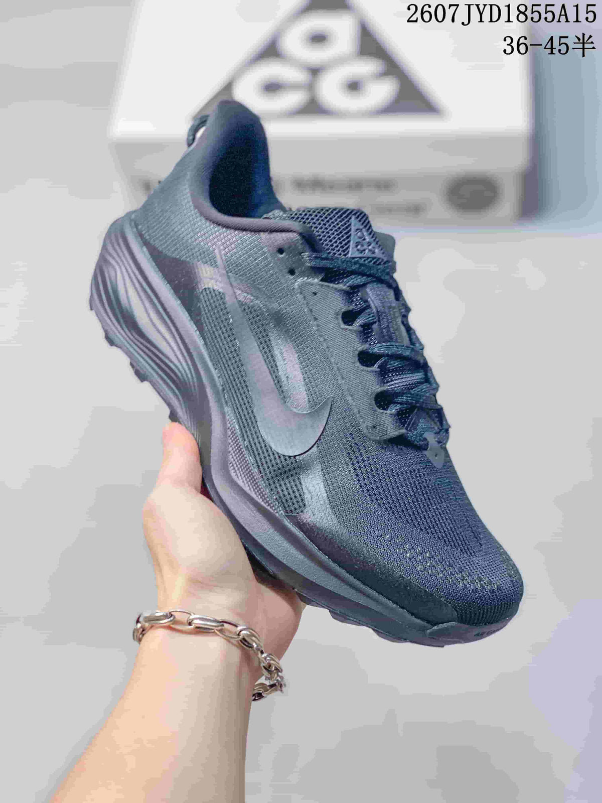 Angled side view of a dark gray Nike ACG Pegasus Trail sneaker showing the Swoosh, woven-look upper, and treaded outsole.