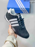 Angled close-up showing the black upper, white stripes, stitching, and side branding.