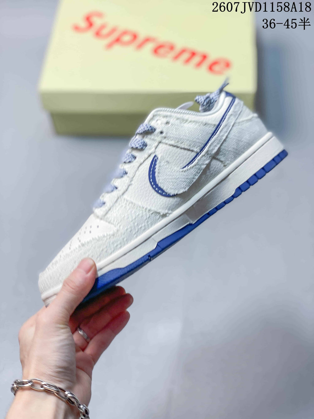 Side profile showing the light gray upper, layered blue-outlined Swoosh, white midsole, and blue outsole.