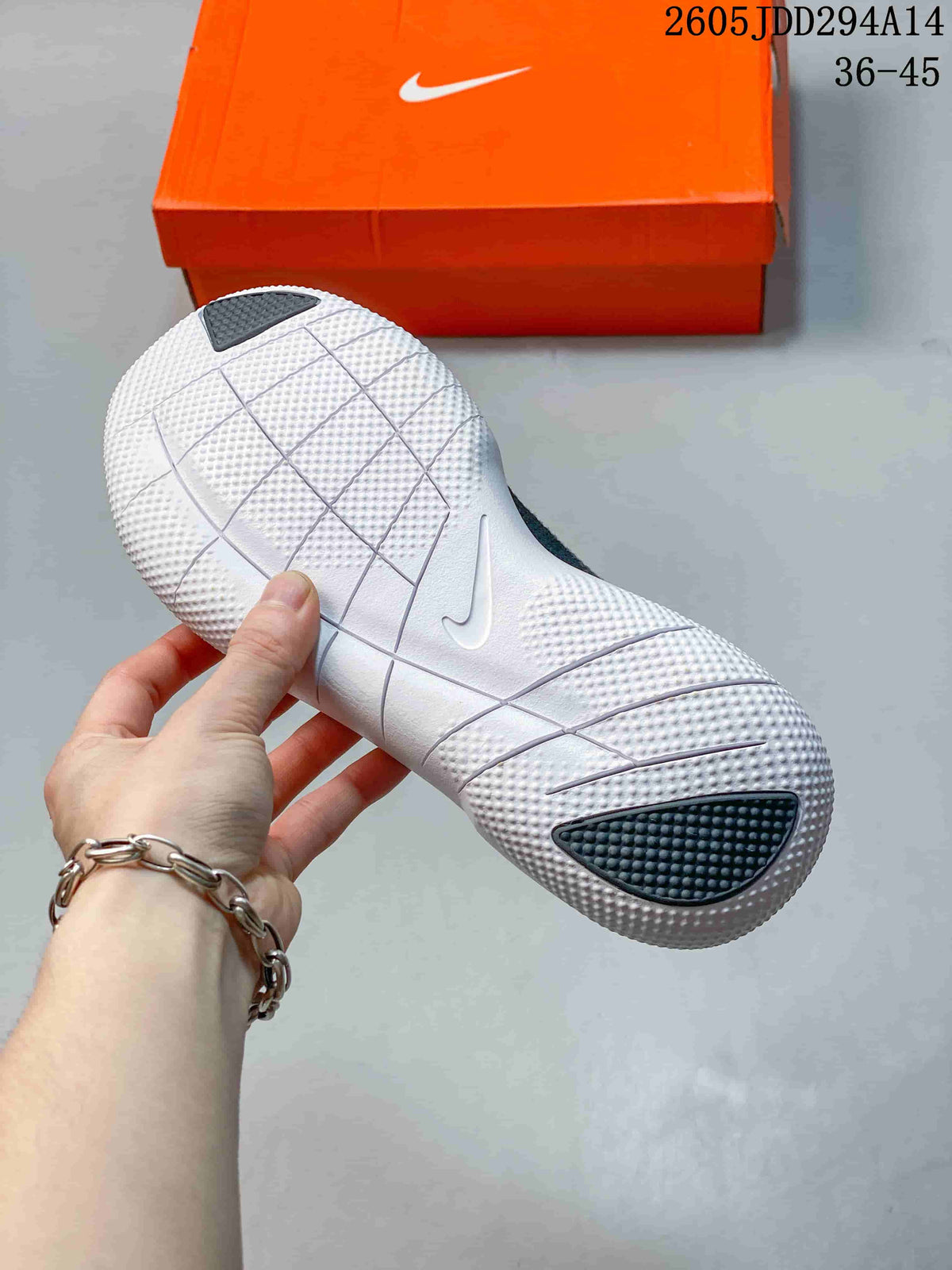Close-up of the white textured outsole with segmented grooves and dark traction areas, with an orange Nike shoebox in the background.