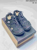 Pair of black The North Face outdoor sandals displayed on a shoebox, showing the strappy upper and front toggle laces.