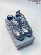 Pair of black and silver Onitsuka Tiger Mexico 66 sneakers displayed on a presentation box.