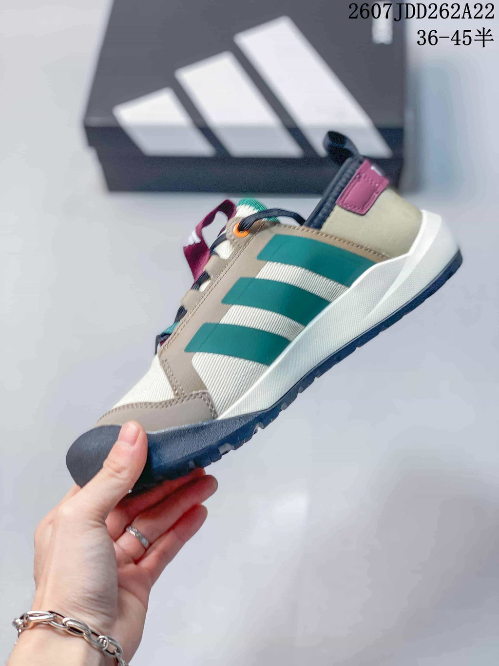 Side view showing the beige upper, green stripes, burgundy heel detail and rugged outsole.