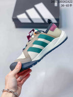 Side view showing the beige upper, green stripes, burgundy heel detail and rugged outsole.