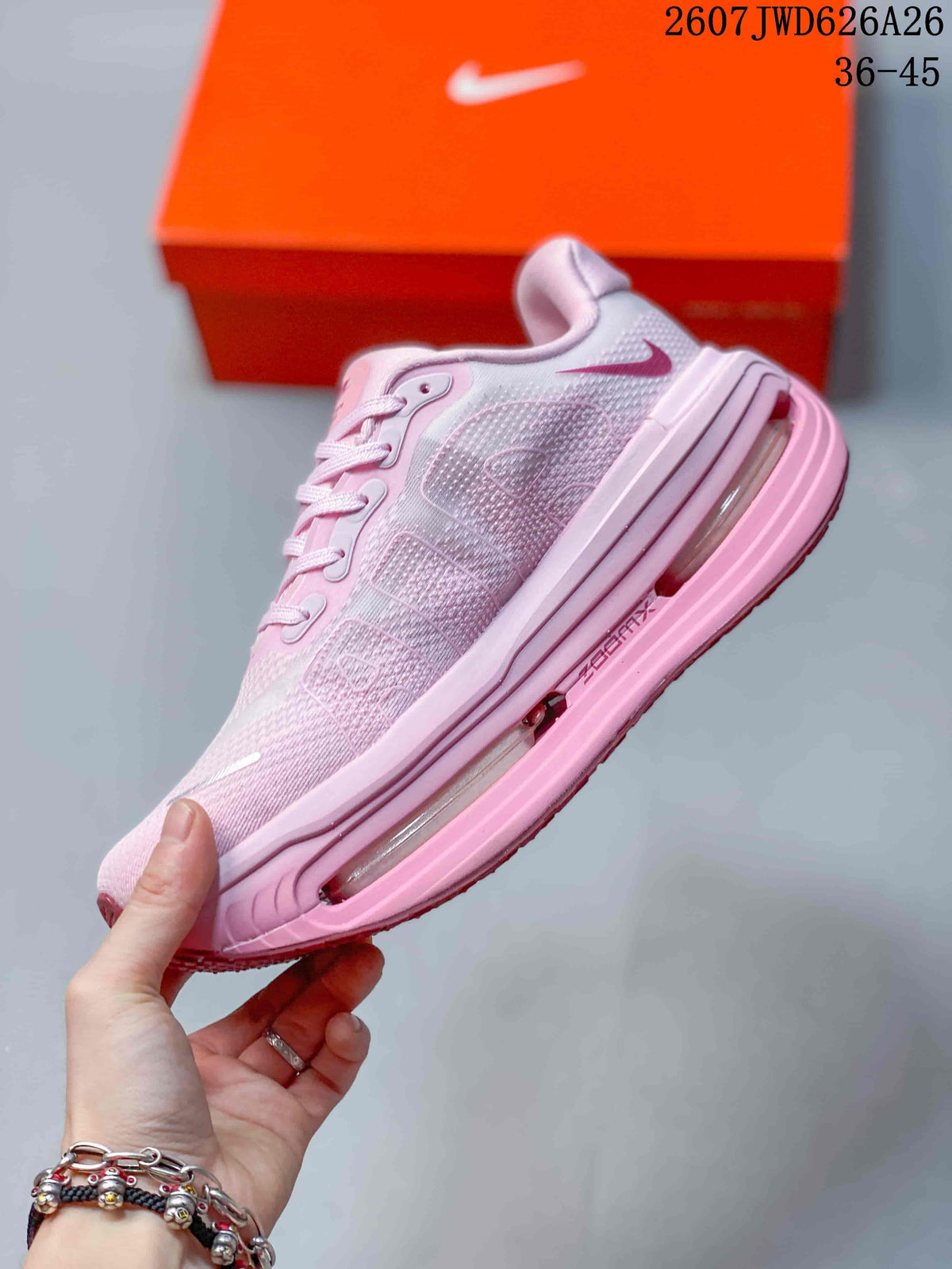 Side view of the pink sneaker showing the Swoosh, textured upper, layered pink midsole, and transparent-looking cushioning unit.