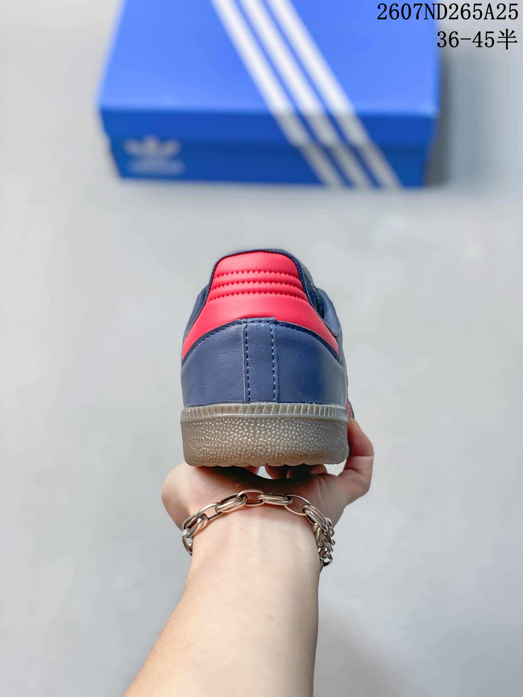 Rear view showing the navy heel, red padded collar detail, stitching, and gum-colored outsole.