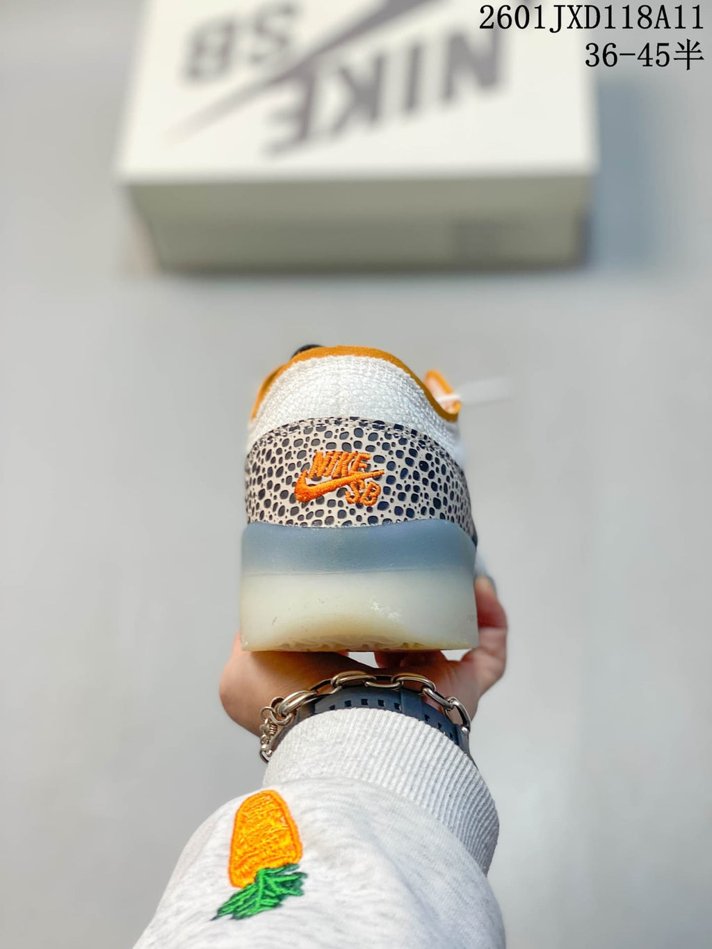 Rear view of the Nike SB PS8 sneaker showing the patterned heel overlay, orange branding details and translucent outsole.