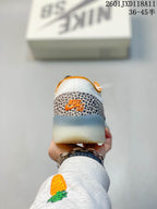 Rear view of the Nike SB PS8 sneaker showing the patterned heel overlay, orange branding details and translucent outsole.