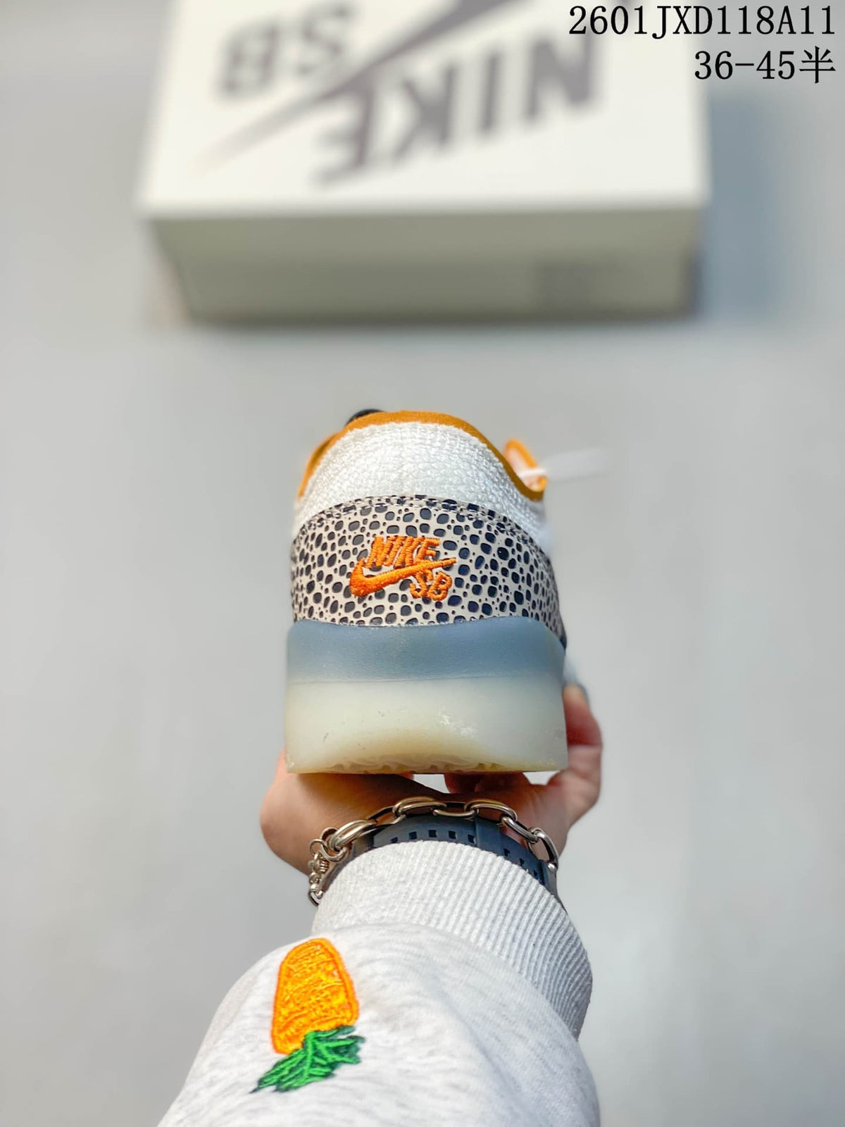 Rear view of the Nike SB PS8 sneaker showing the patterned heel overlay, orange branding details and translucent outsole.