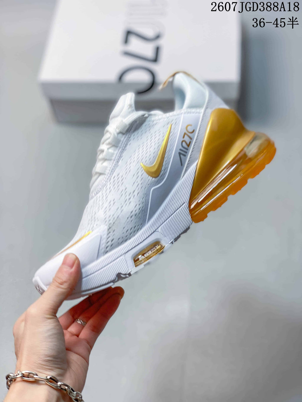 Side profile showing the white patterned upper, gold Swoosh, and translucent gold heel unit.