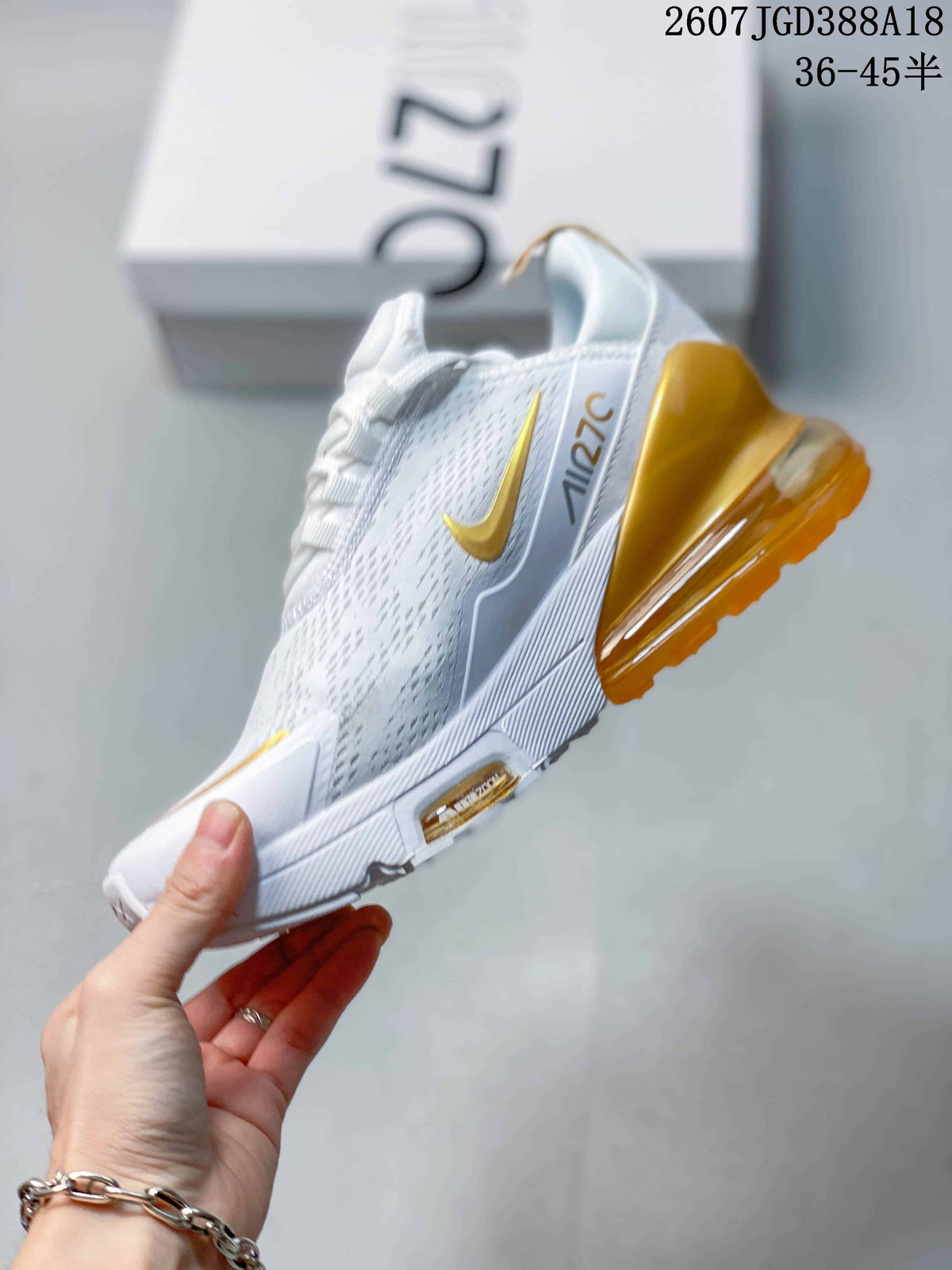 Side profile showing the white patterned upper, gold Swoosh, and translucent gold heel unit.