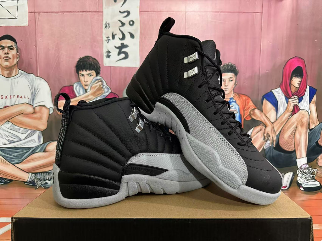 Pair of black and grey Jordan 12 high-top sneakers shown at an angle